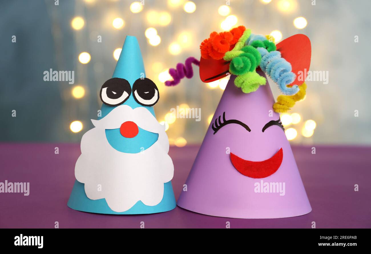 Funny handmade party hats on purple table against blurred lights, closeup  Stock Photo - Alamy