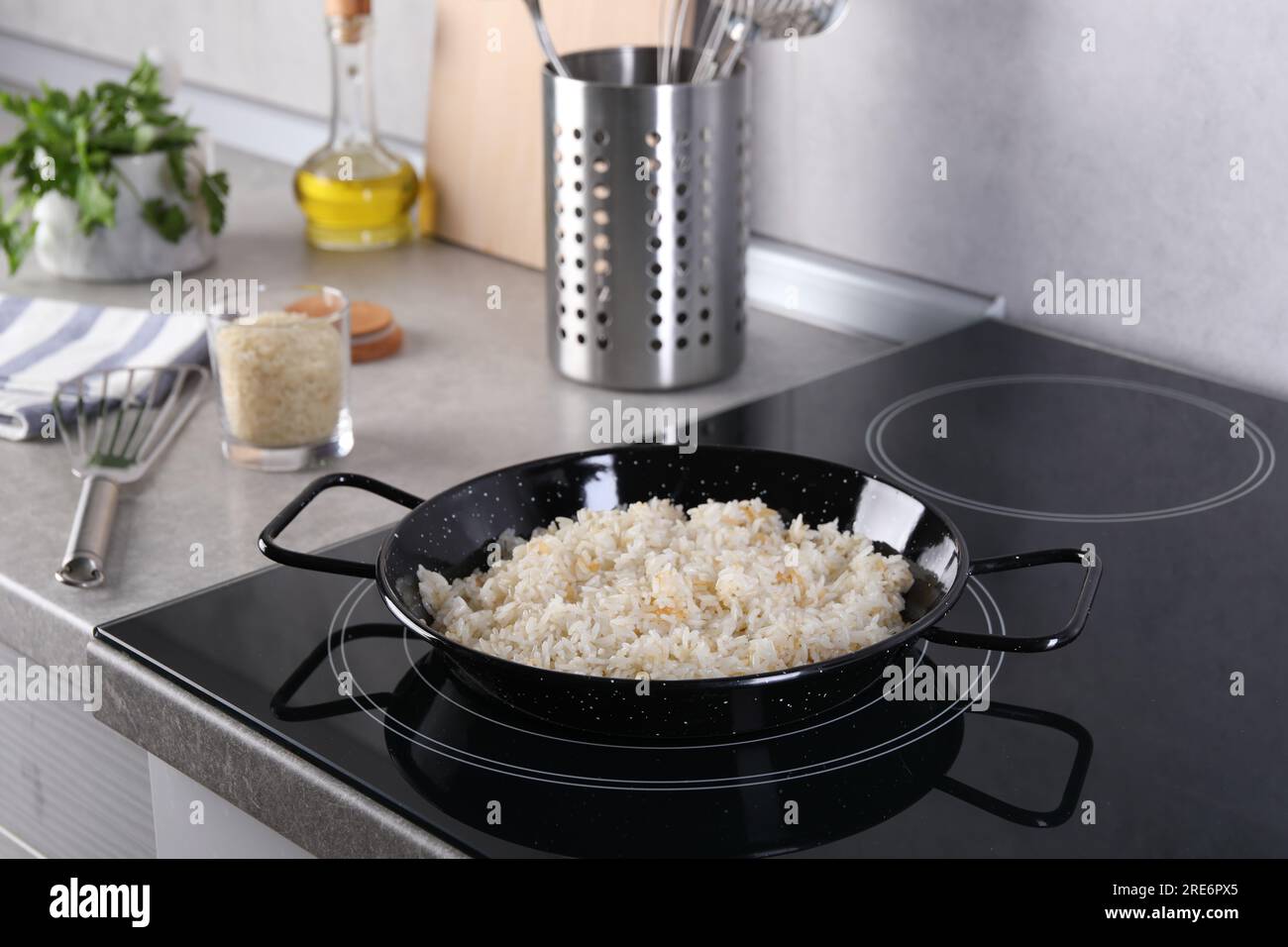 Cooking tasty rice on induction stove in kitchen Stock Photo - Alamy
