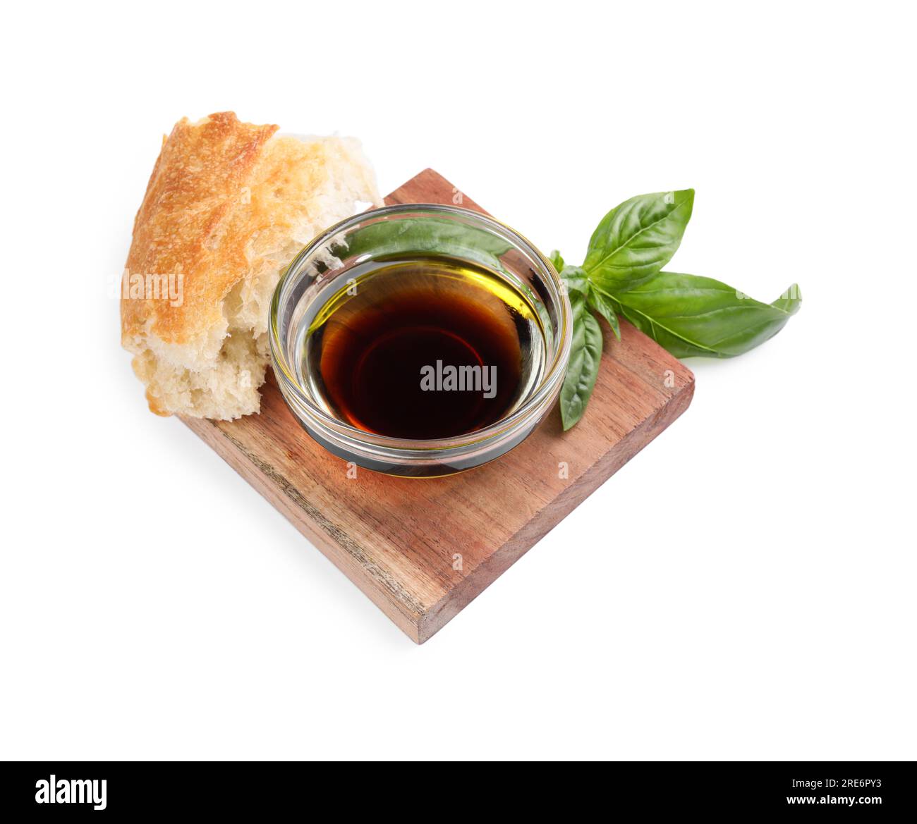 Bowl of organic balsamic vinegar with oil, basil and bread isolated on