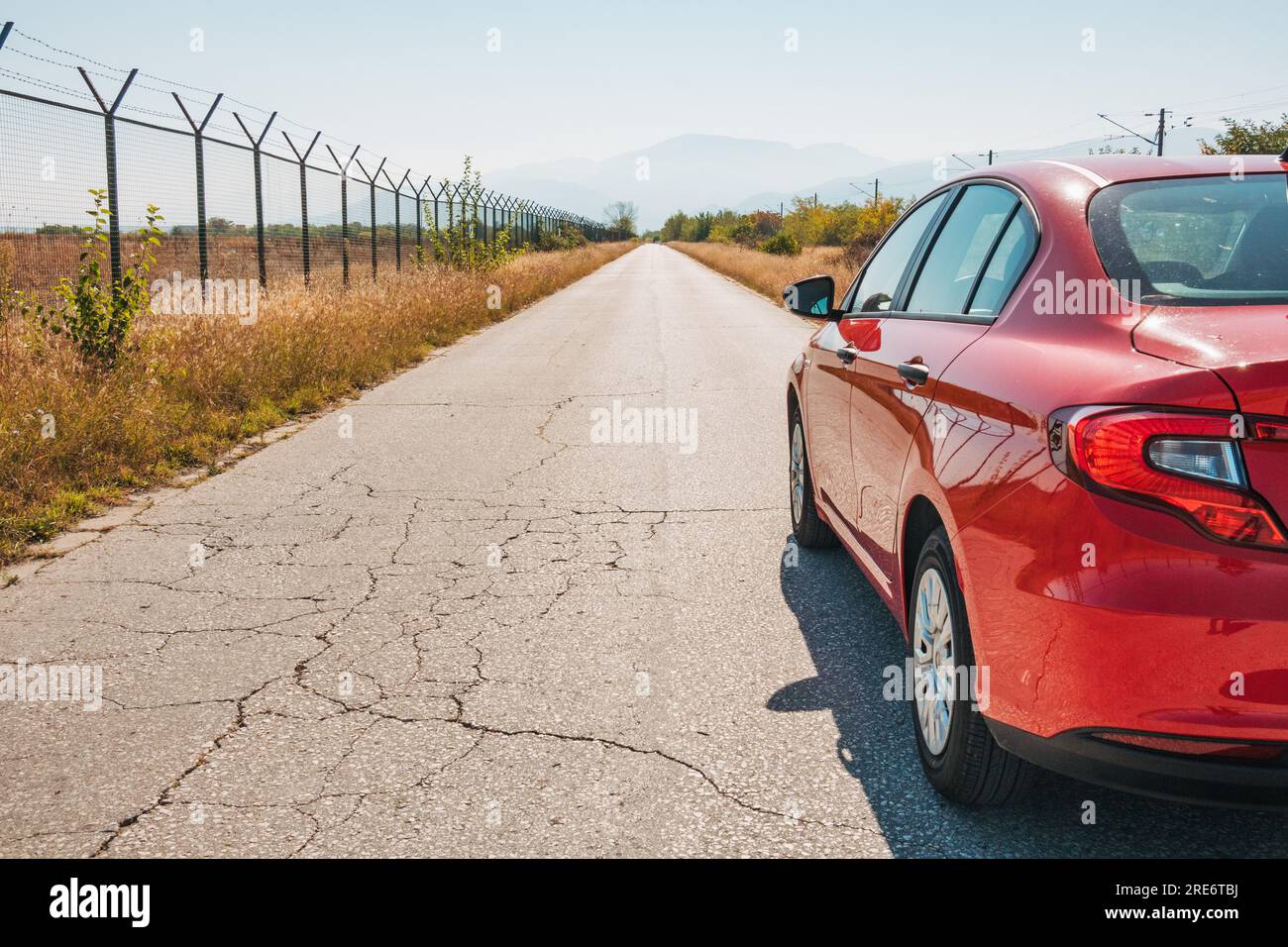 a red Fiat Tipo sedan parked on a straight and empty road in Plovdiv, Bulgaria Stock Photo