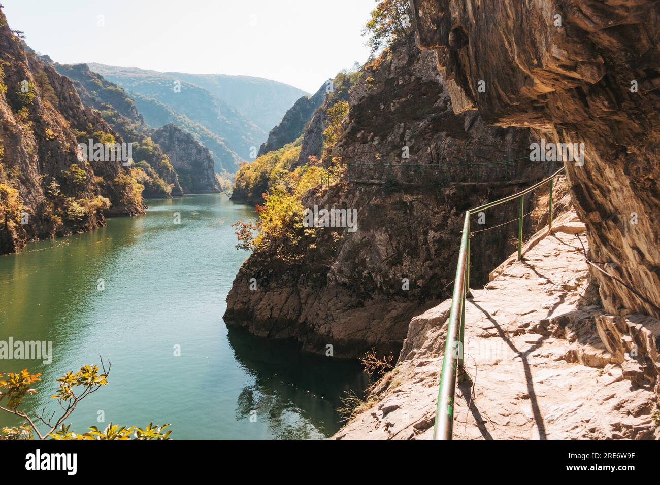 a walkway with a guardrail along the canyon wall of Matka Gorge in North Macedonia Stock Photo