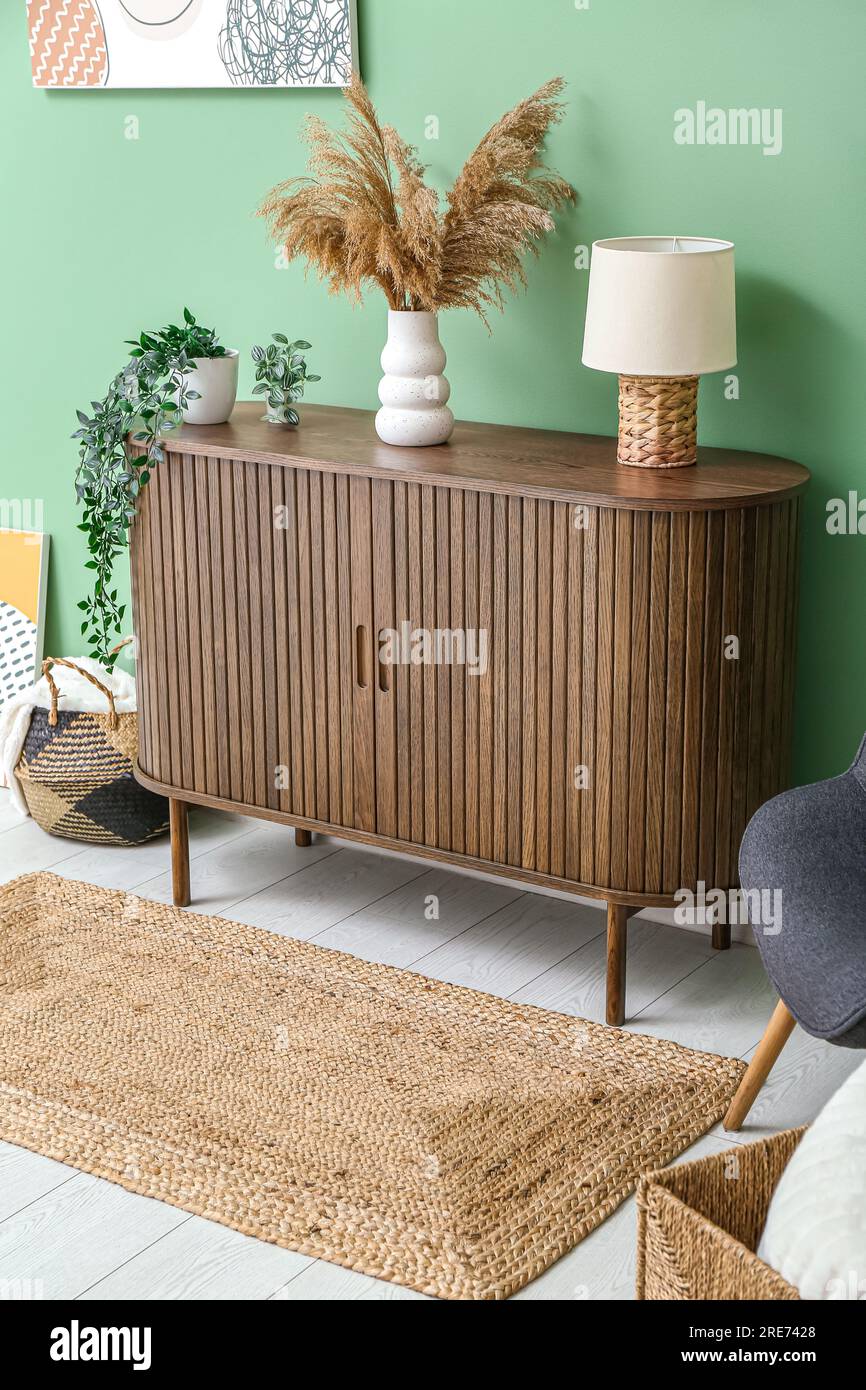 Stylish interior of living room with drawers, pampas grass and wicker ...