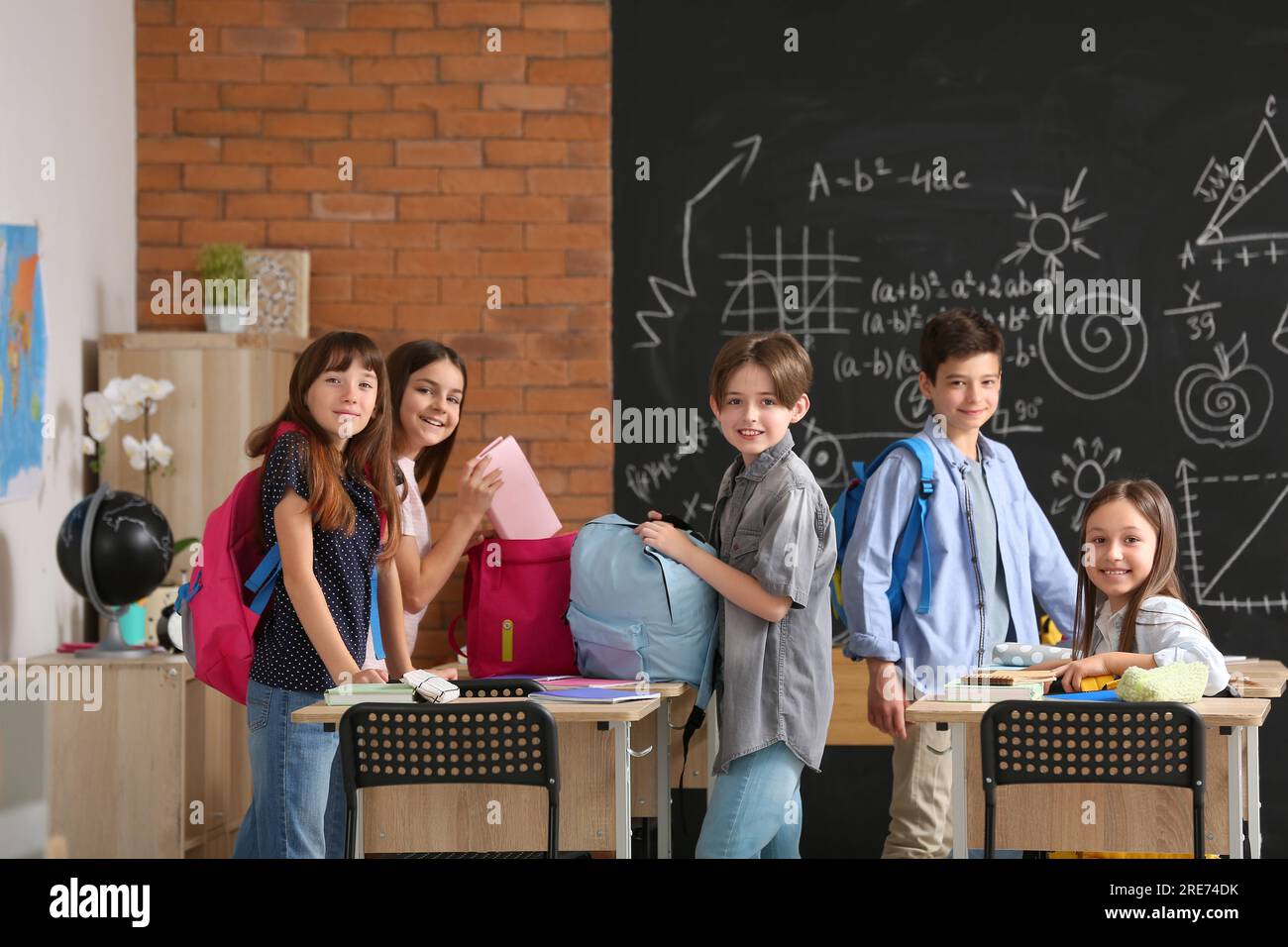 Little pupils with backpacks in classroom Stock Photo Alamy