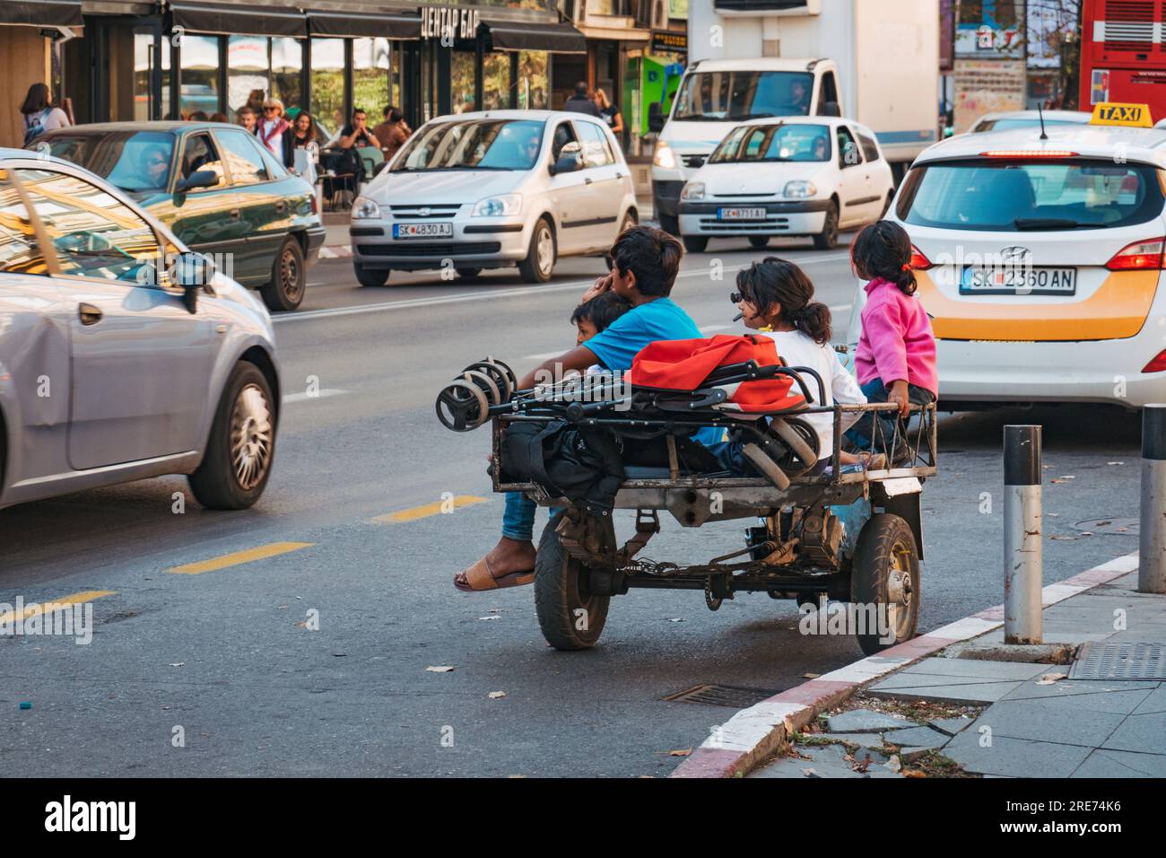 Homeless children sit on the back of a motorized tricycle on a street in Skopje, North Macedonia Stock Photo