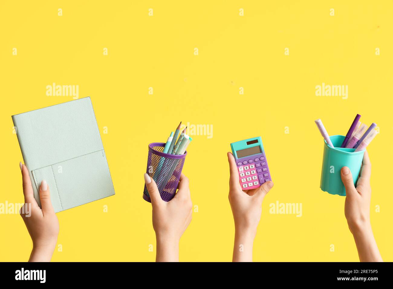 Female hands with school supplies on yellow background Stock Photo - Alamy