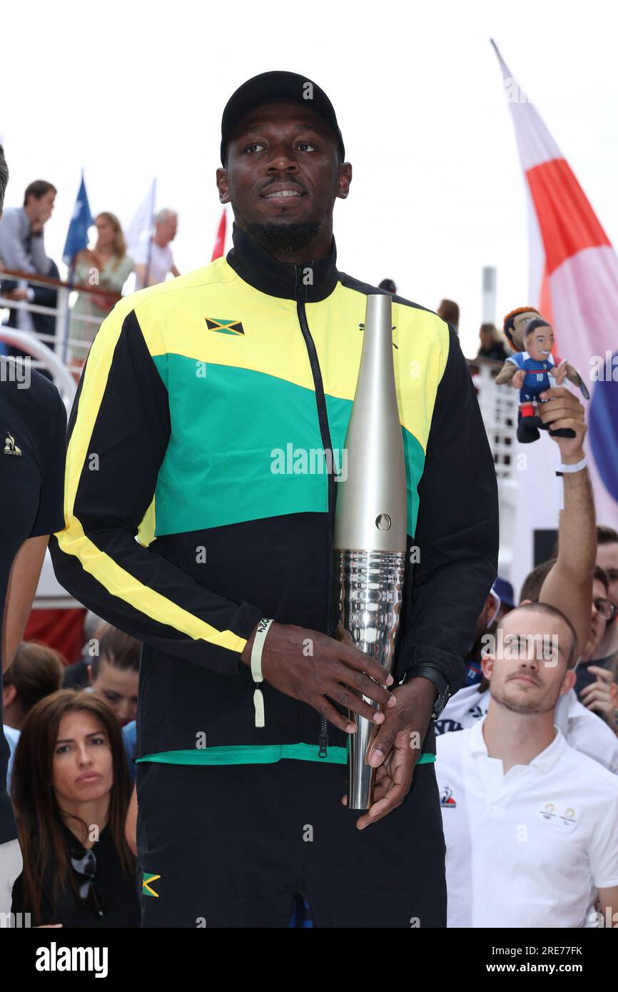 Usain Bolt poses with the Paris 2024 Olympic and Paralympic Torch near