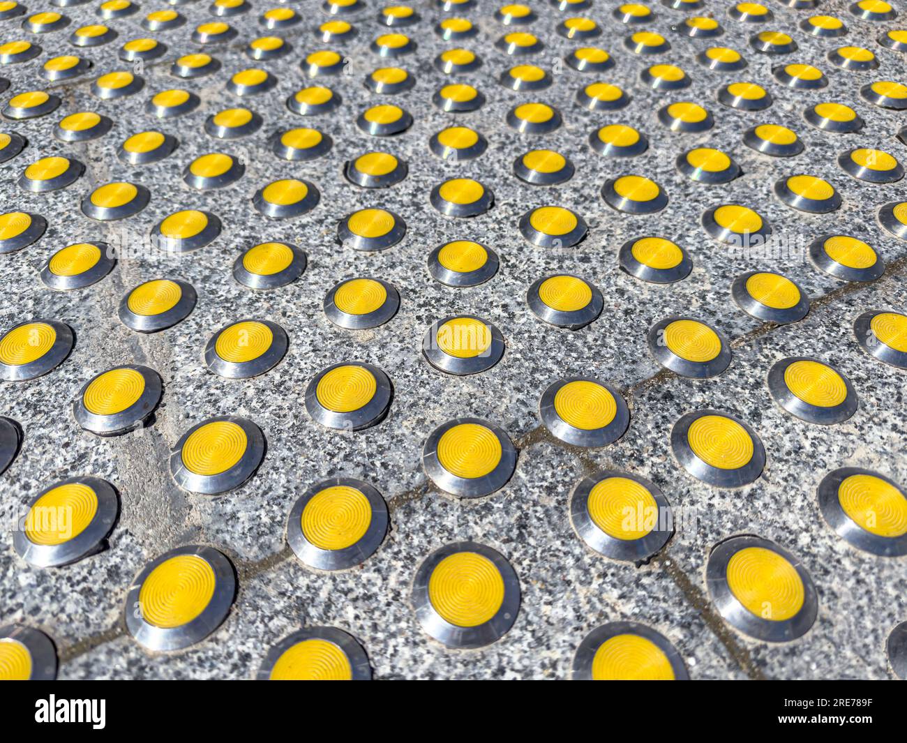 tactile indicators, closeup view. braille block on granite sidewalk for visually impaired. Stock Photo