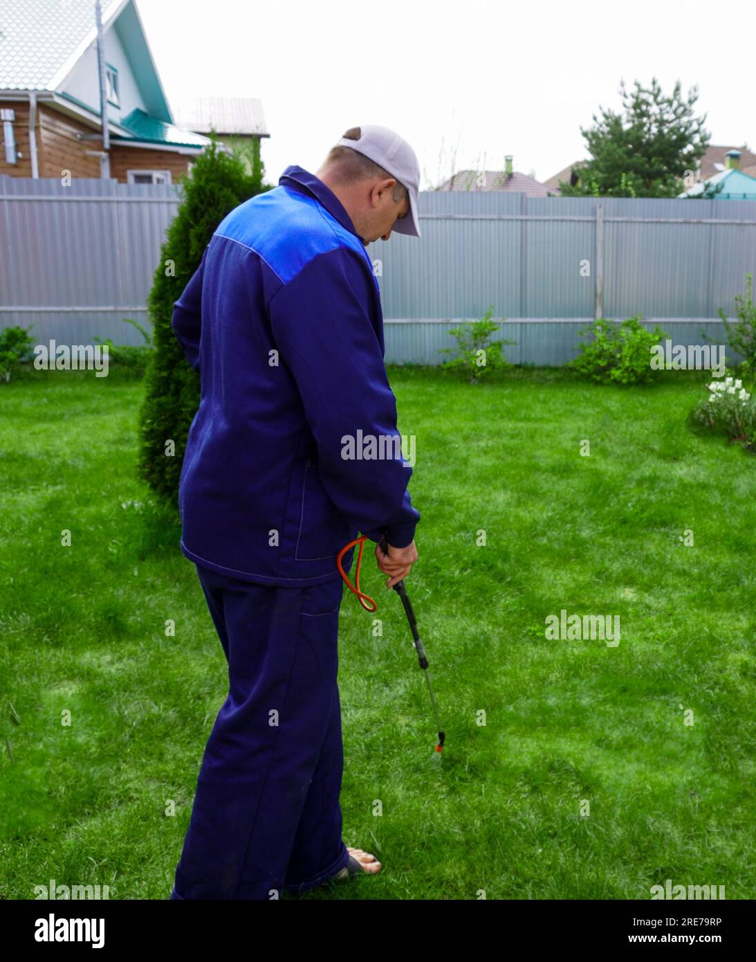 A man works in the garden, spraying weeds from a sprayer Stock Photo ...