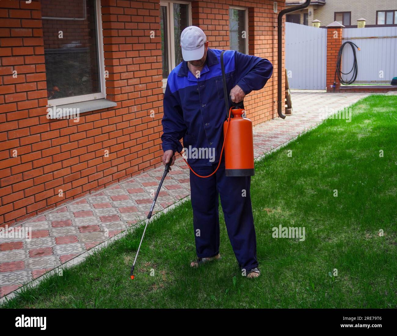 A man works in the garden, spraying weeds from a sprayer Stock Photo ...