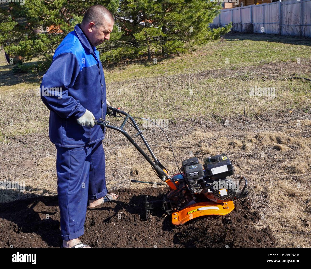 A man works in a vegetable garden in early spring. Digs the ground ...