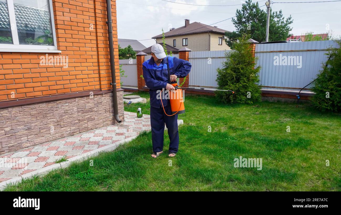 A man works in the garden, spraying weeds from a sprayer Stock Photo ...