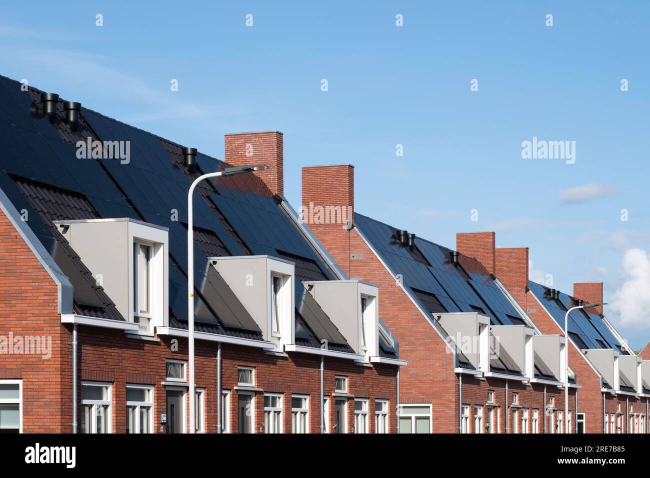 Modern new social rental housing in Lemmer, the Netherlands, with solar panels on the tiled roofs. Sustainable energy. Electric power generation Stock Photo