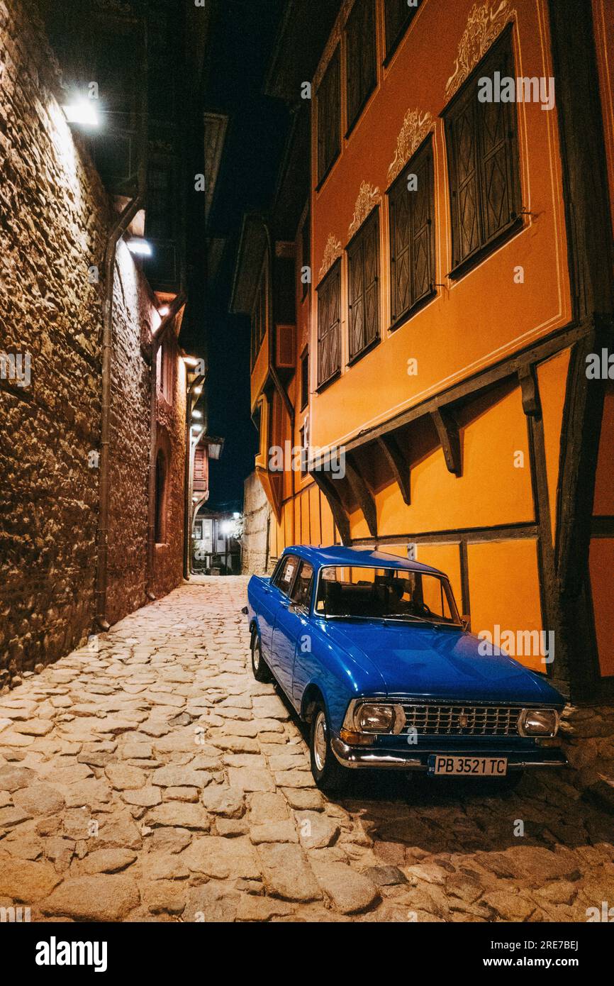 a royal blue Moskvitch 412 car in great condition parked on a street at night in the old town of Plovdiv, Bulgaria Stock Photo