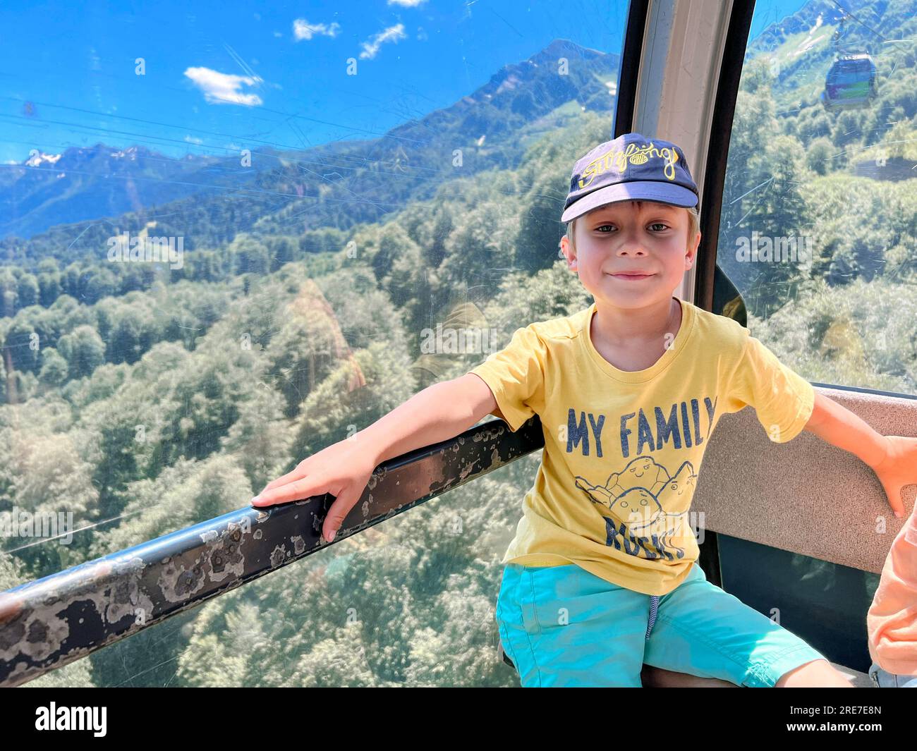 little child enjoying journey in cabin of funicular cable railway . Beautiful mountains on background. High quality photo Stock Photo