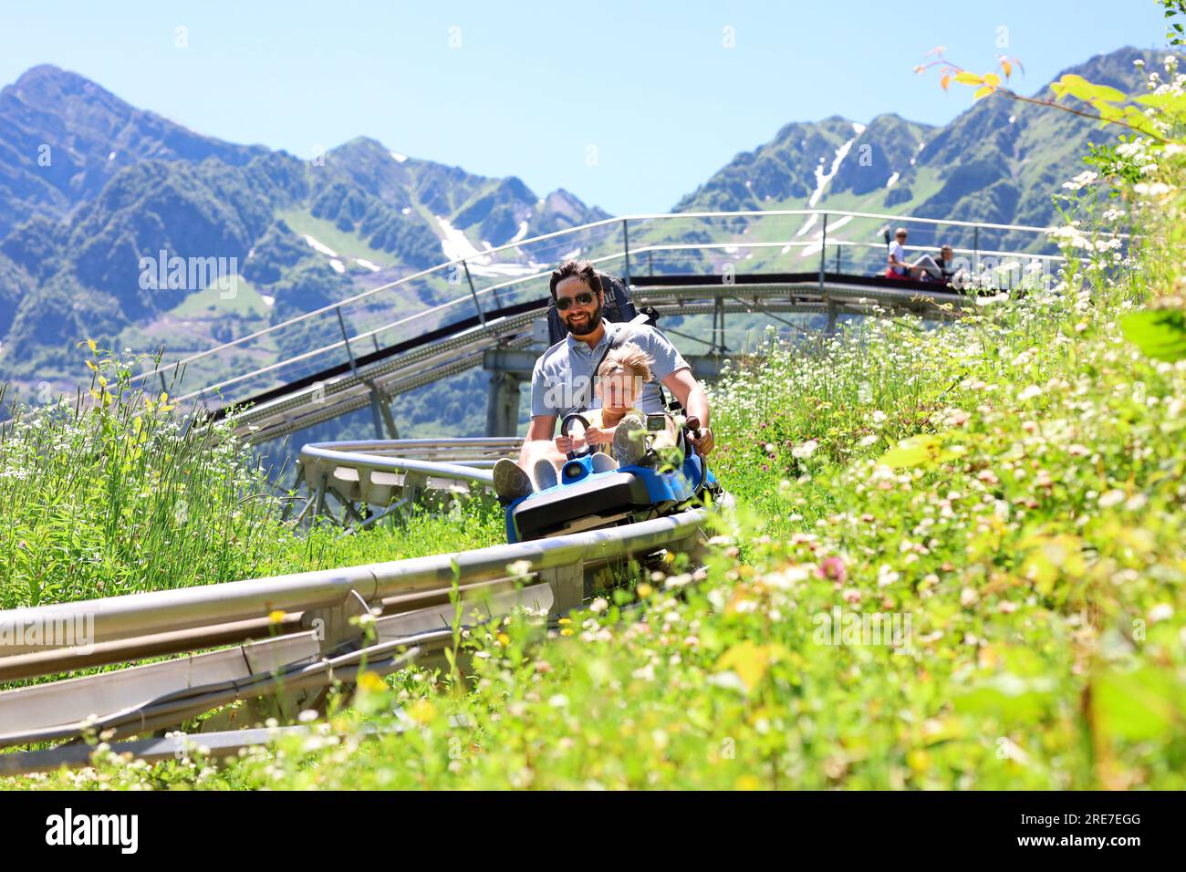 father and child having ride on summer toboggan called Rodelbahn