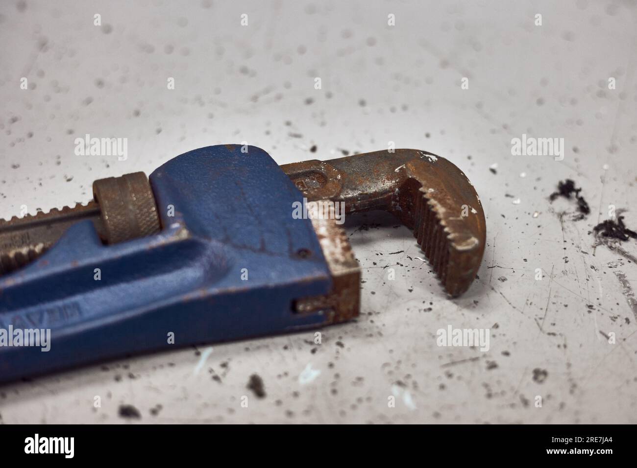 Rusty pipe wrench jaws on the working table. Stock Photo