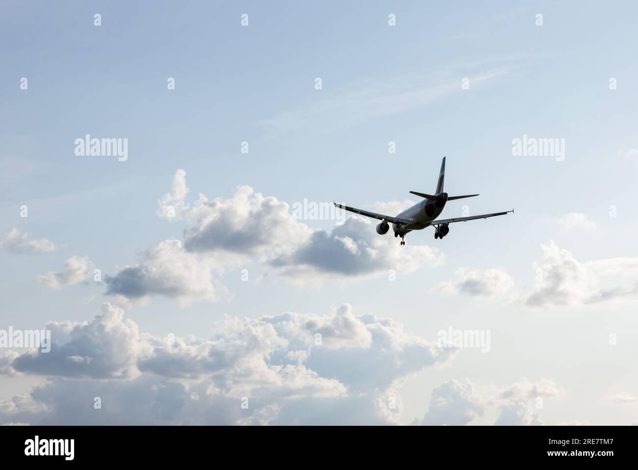 A plane lands at Duesseldorf International Airport, north rhine-westphalia, with the sun and blue sky in the background. Stock Photo