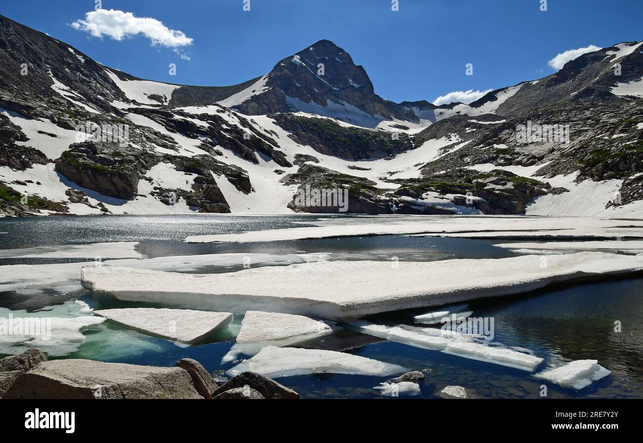 blue lake with ice floes and mount toll on  sunny  summer day from lake  shoreline  in the indian peaks wilderness area, near nederland, colorado Stock Photo
