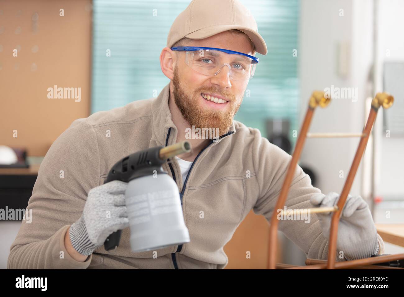 worker plumber using blowtorch for soldering copper fittings Stock
