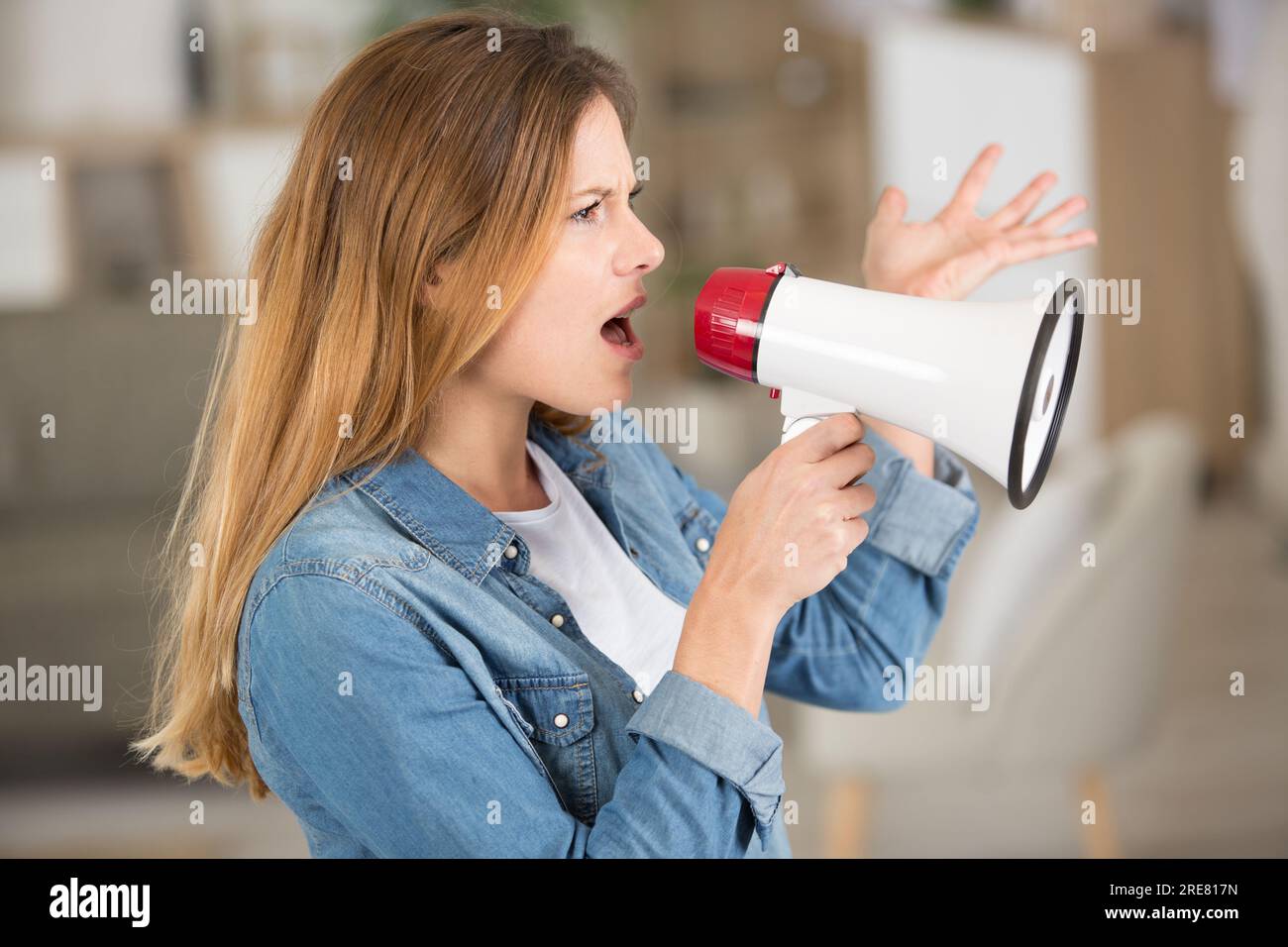 young woman yelling through megaphone Stock Photo Alamy