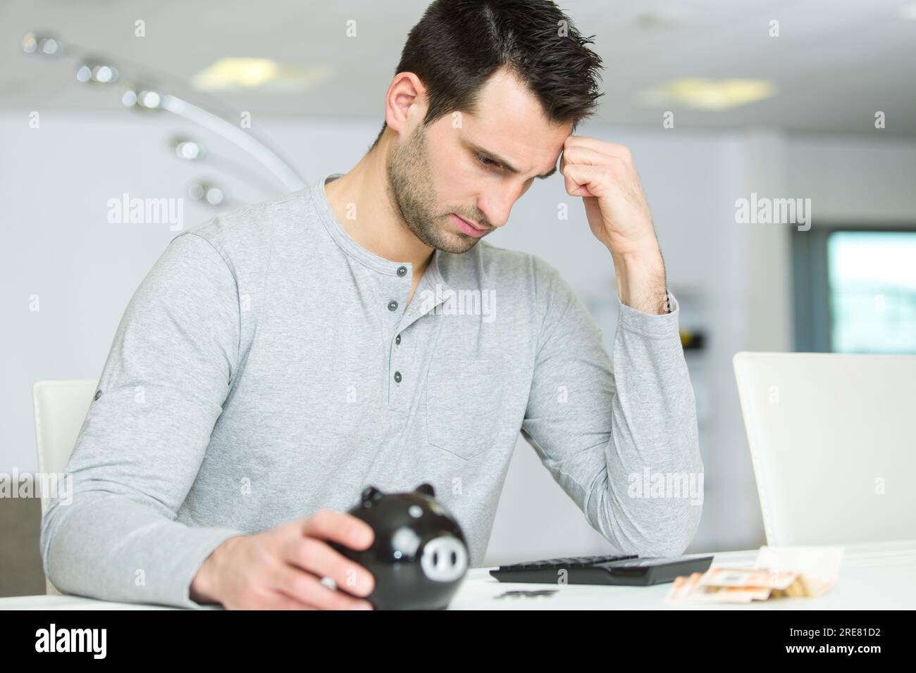 worried man with calculator counting contents of his piggy bank Stock ...