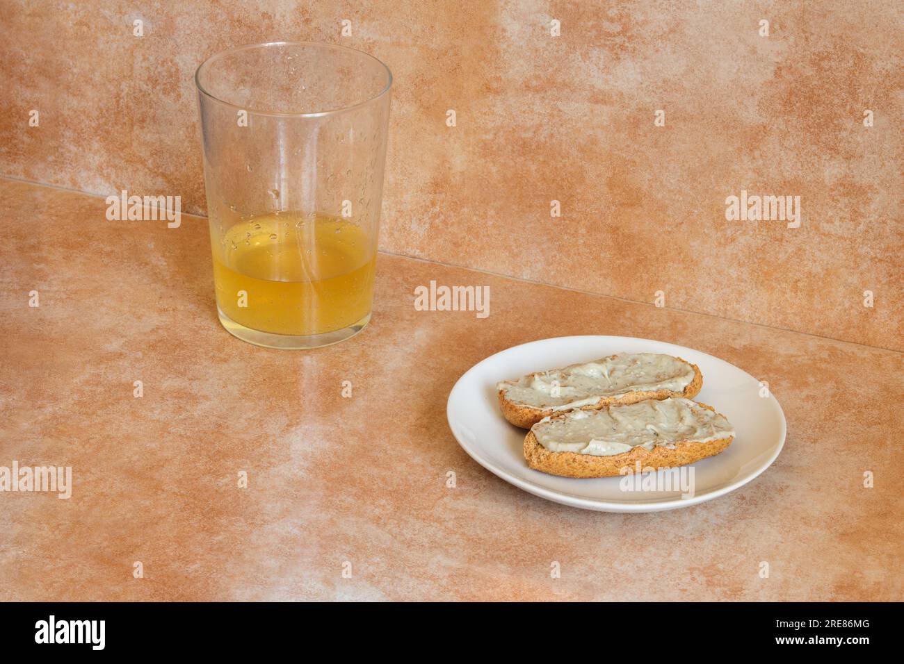 A small plate with two whole wheat toast with cream of Cabrales cheese with cider near a glass of cider with a shot of cider on an abstract studio bac Stock Photo