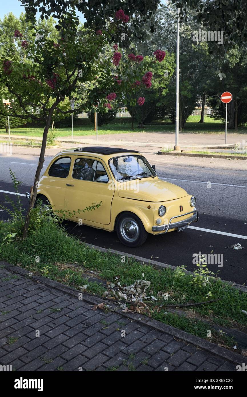 1957 Fiat 500 parked by the edge of a road next to a park at sunset ...