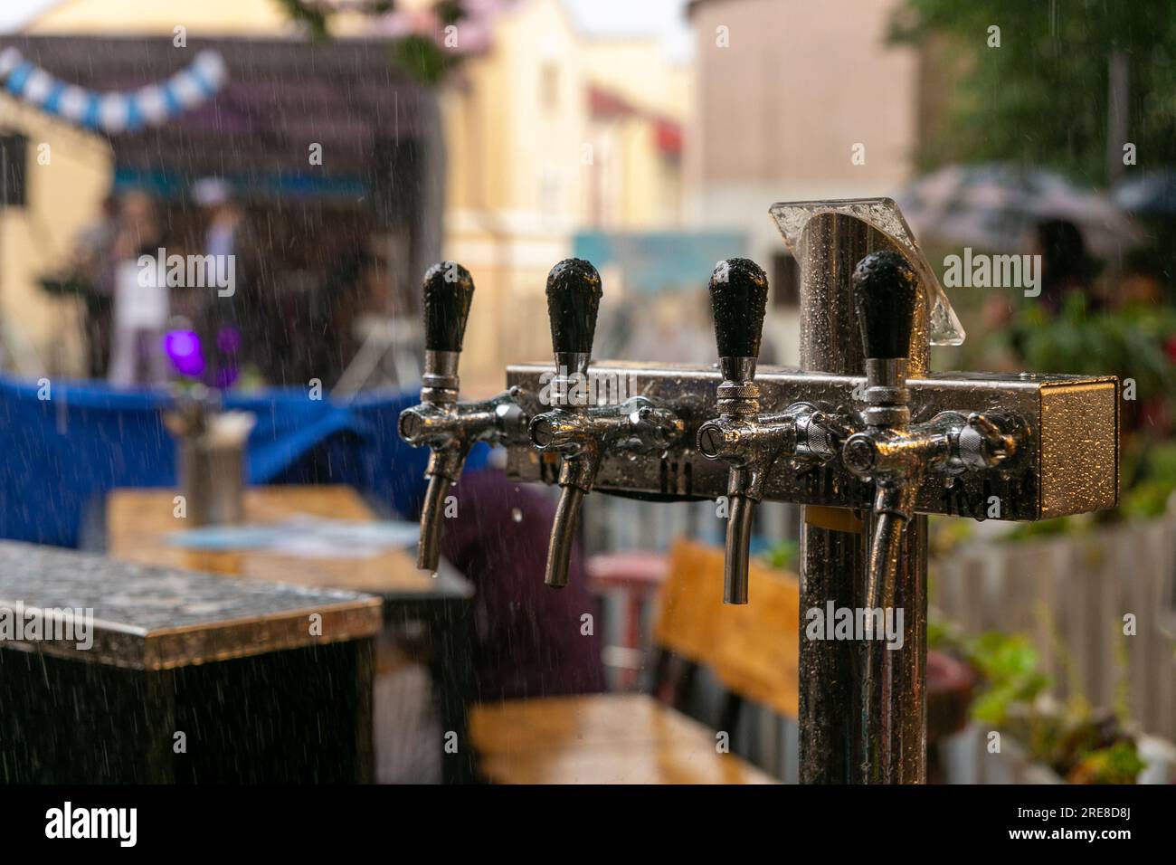 Chromed taps for draft beer in a street cafe under the rain. Detail of beer machine, beer dispenser, close-up, selective focus, retro style Stock Photo