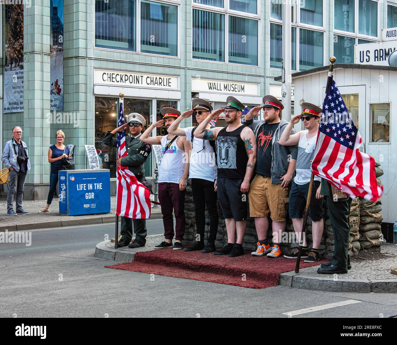 Tourist posing at Checkpoint Charlie Border post, Allied border crossing during cold war Friederichstrasse, Berlin, Germany Stock Photo