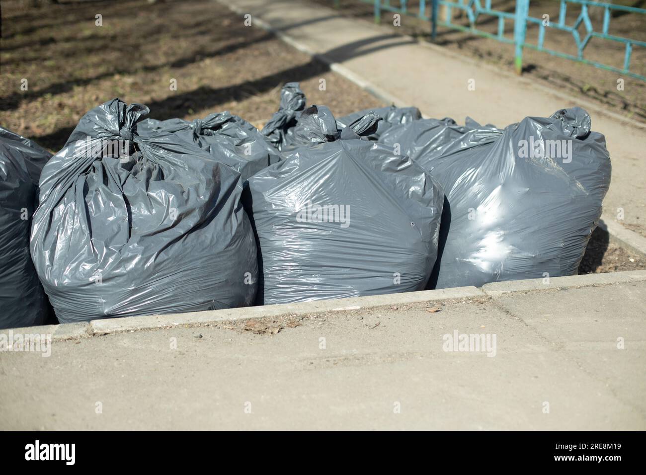 https://c8.alamy.com/comp/2RE8M19/garbage-bags-in-park-black-packets-yard-cleaning-waste-bag-2RE8M19.jpg