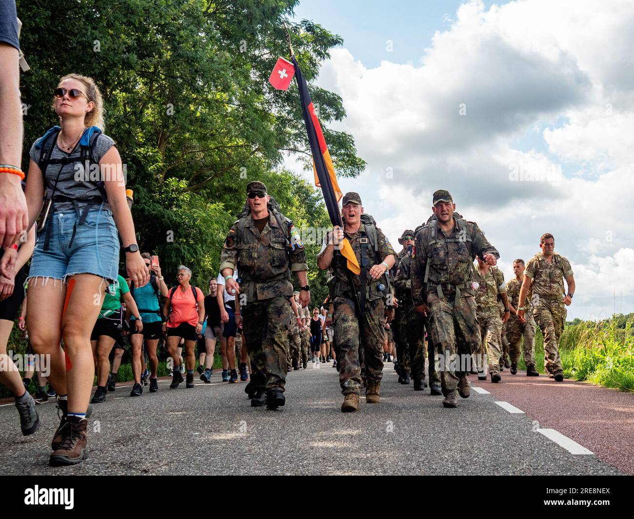 Soldiers are seen singing military songs. Since it is the world's biggest multi-day walking event, The International Four Days Marches (in Dutch 'De Vierdaagse') is seen as the prime example of sportsmanship and international bonding between military servicemen, women and civilians from many different countries. This year, it was the 105 edition and the official amount of walkers registered was 43,363 from 77 countries. Participants can choose to walk 30km, 40km, or 50km per day. On the last day, 39,019 walkers crossed the finish line. After a festive entry on the Via Gladiola, they received t Stock Photo