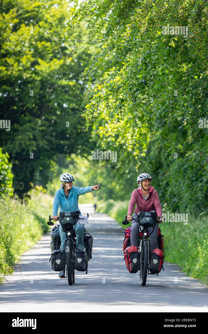 Two senior women cycle touring with full panniers Stock Photo Alamy