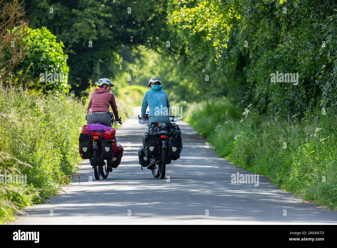 Two senior women cycle touring with full panniers Stock Photo Alamy