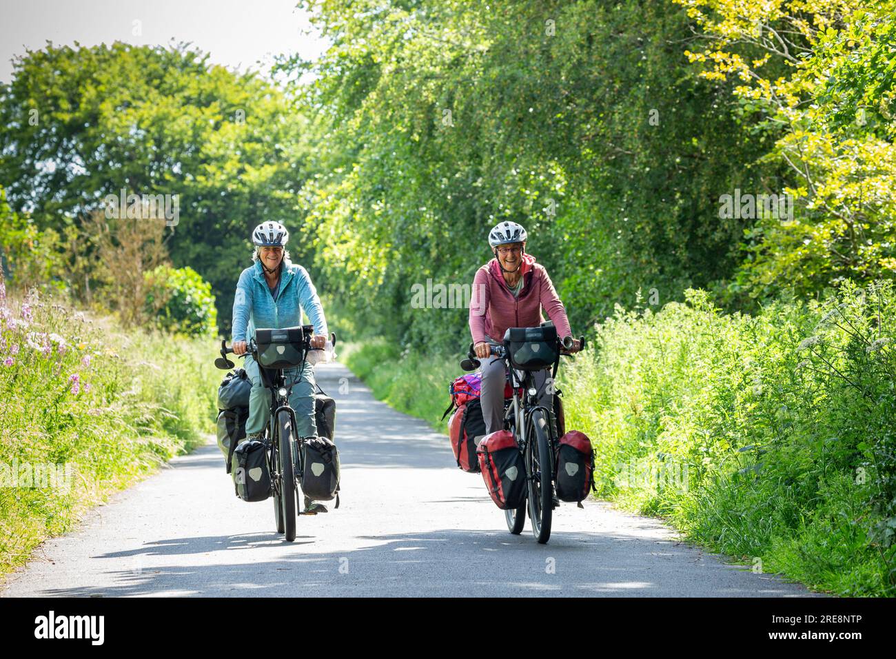 Two senior women cycle touring with full panniers Stock Photo Alamy