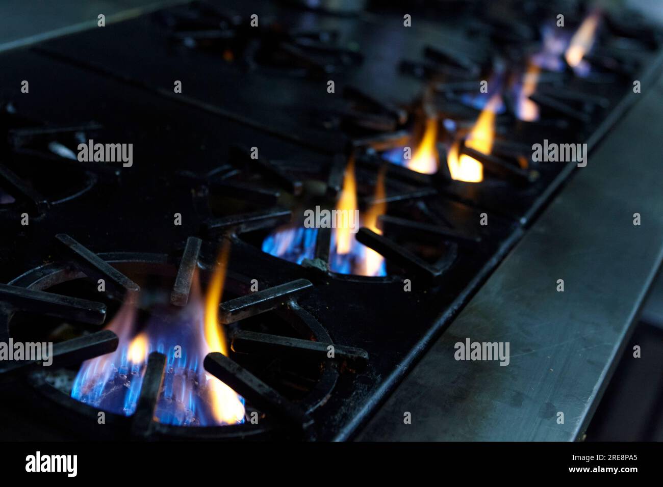 5 gas burners lit in a restaurant kitchen Stock Photo