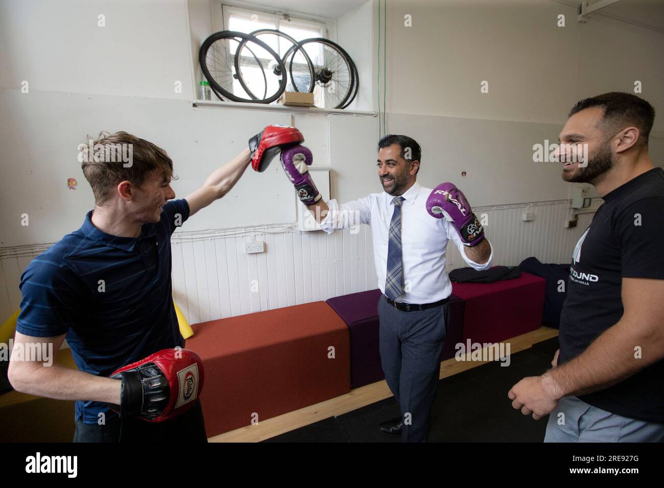 First Minister Humza Yousaf sparring with Bradley MacGregor (left) and Darius Black (right) during a visit to youth organisation, Heavy Sound in Cockenzie, East Lothian, which aims to transform the lives of vulnerable and disengaged young people and adults across East Lothian, Midlothian and Edinburgh. Picture date: Wednesday July 26, 2023. Stock Photo