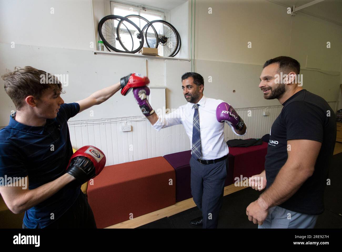 First Minister Humza Yousaf sparring with Bradley MacGregor (left) and Darius Black (right) during a visit to youth organisation, Heavy Sound in Cockenzie, East Lothian, which aims to transform the lives of vulnerable and disengaged young people and adults across East Lothian, Midlothian and Edinburgh. Picture date: Wednesday July 26, 2023. Stock Photo