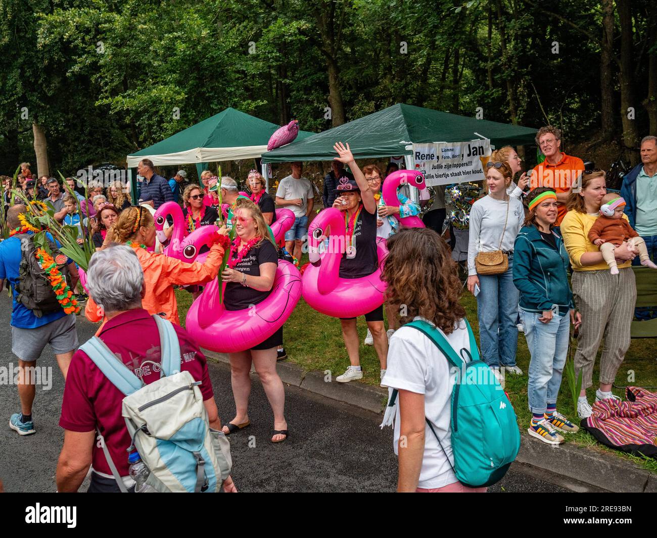 July 21, 2023, Nijmegen, Netherlands: People wearing pink flamingos are seen cheering the walkers. Since it is the worldâ€™s biggest multi-day walking event, The International Four Days Marches (in Dutch 'De Vierdaagse') is seen as the prime example of sportsmanship and international bonding between military servicemen, women and civilians from many different countries. This year, it was the 105 edition and the official amount of walkers registered was 43,363 from 77 countries. Participants can choose to walk 30km, 40km, or 50km per day. On the last day, 39,019 walkers crossed the finish line. Stock Photo