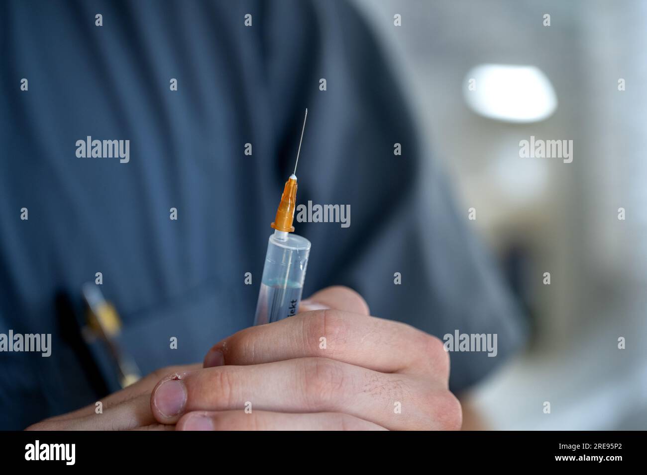 Coburg, Germany. 23rd July, 2023. A nursing student holds a syringe in his hand. This week, the first graduates in generalist nursing in Bavaria will receive their graduation certificates. Credit: Pia Bayer/dpa/Alamy Live News Stock Photo