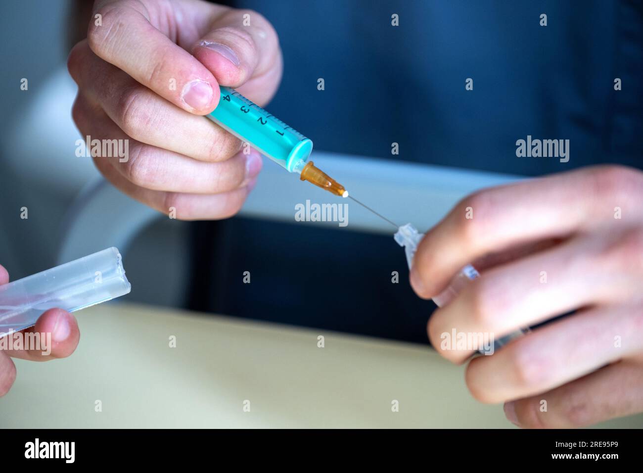 Coburg, Germany. 23rd July, 2023. A nursing student practices drawing up a syringe with a saline solution. This week, the first graduates in generalist nursing in Bavaria will receive their graduation certificates. Credit: Pia Bayer/dpa/Alamy Live News Stock Photo
