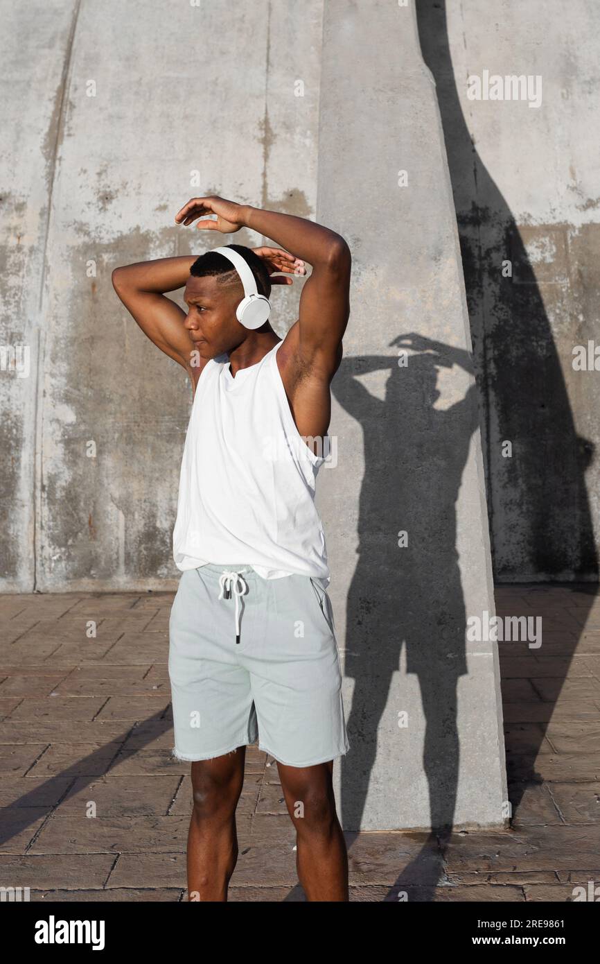 Confident African American runner warming up and doing stretching exercise while preparing for active training Stock Photo