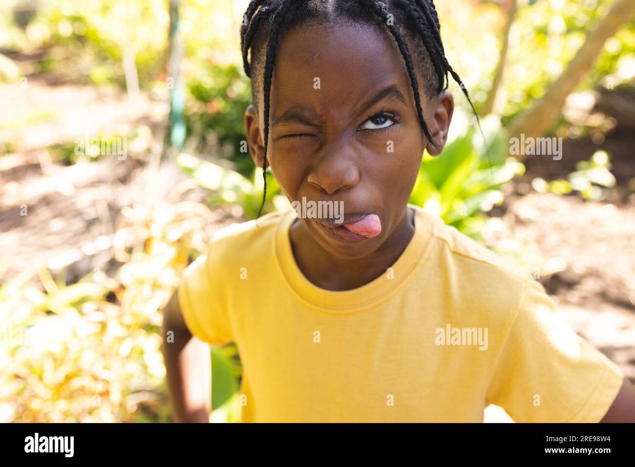 African american boy wearing yellow t-shirt, making funny face in garden Stock Photo