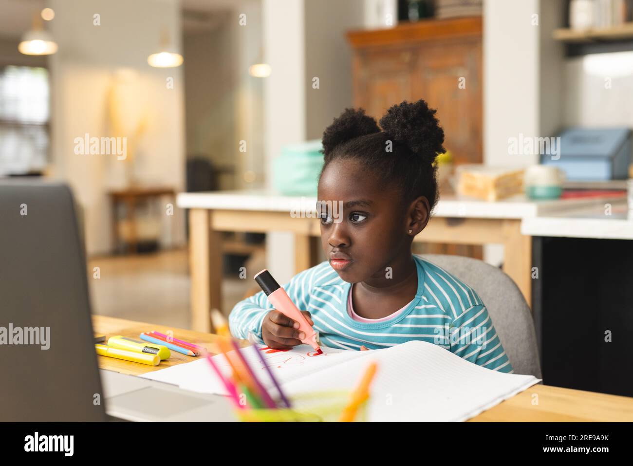 African american girl sitting on table using laptop for online lesson ...