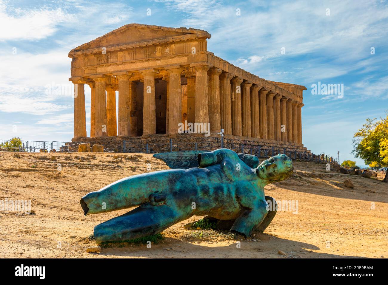 Bronze statue of Icarus in front of the Temple of Concordia at the Valley of the Temples. Temple of Concordia and the statue of Fallen Icarus, in the Stock Photo