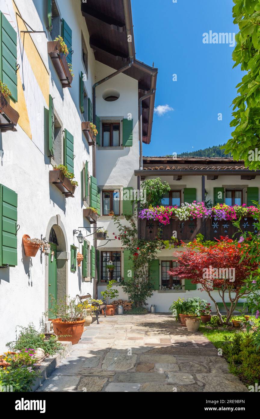 Arta Terme, Italy (15th July 2023) - A typical and well kept house with colourful flowers of geranium on the balconies of the alpine area of Carnia Stock Photo