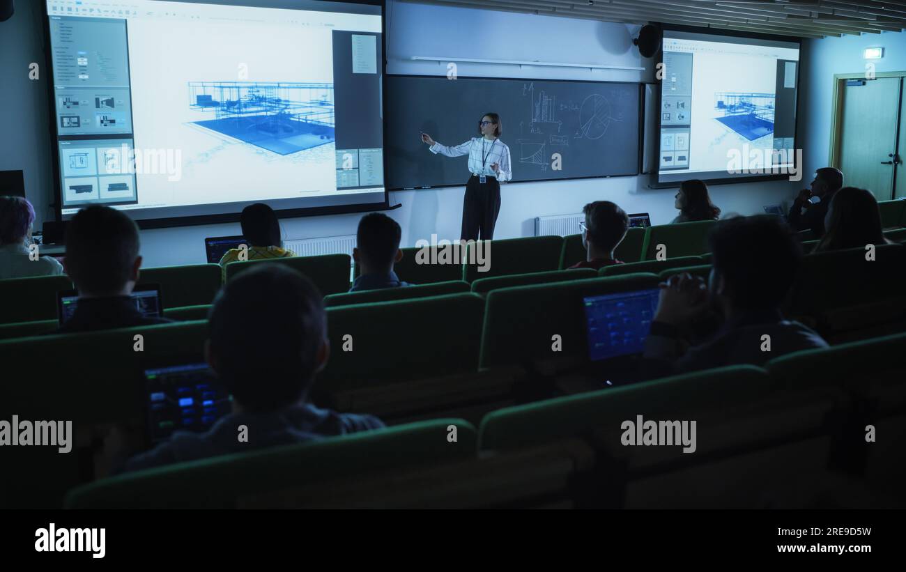 Young Female Teacher Giving a Data Science Lecture to Diverse Multiethnic Group of Female and Male Students in Dark College Room. Projecting Slideshow Stock Photo
