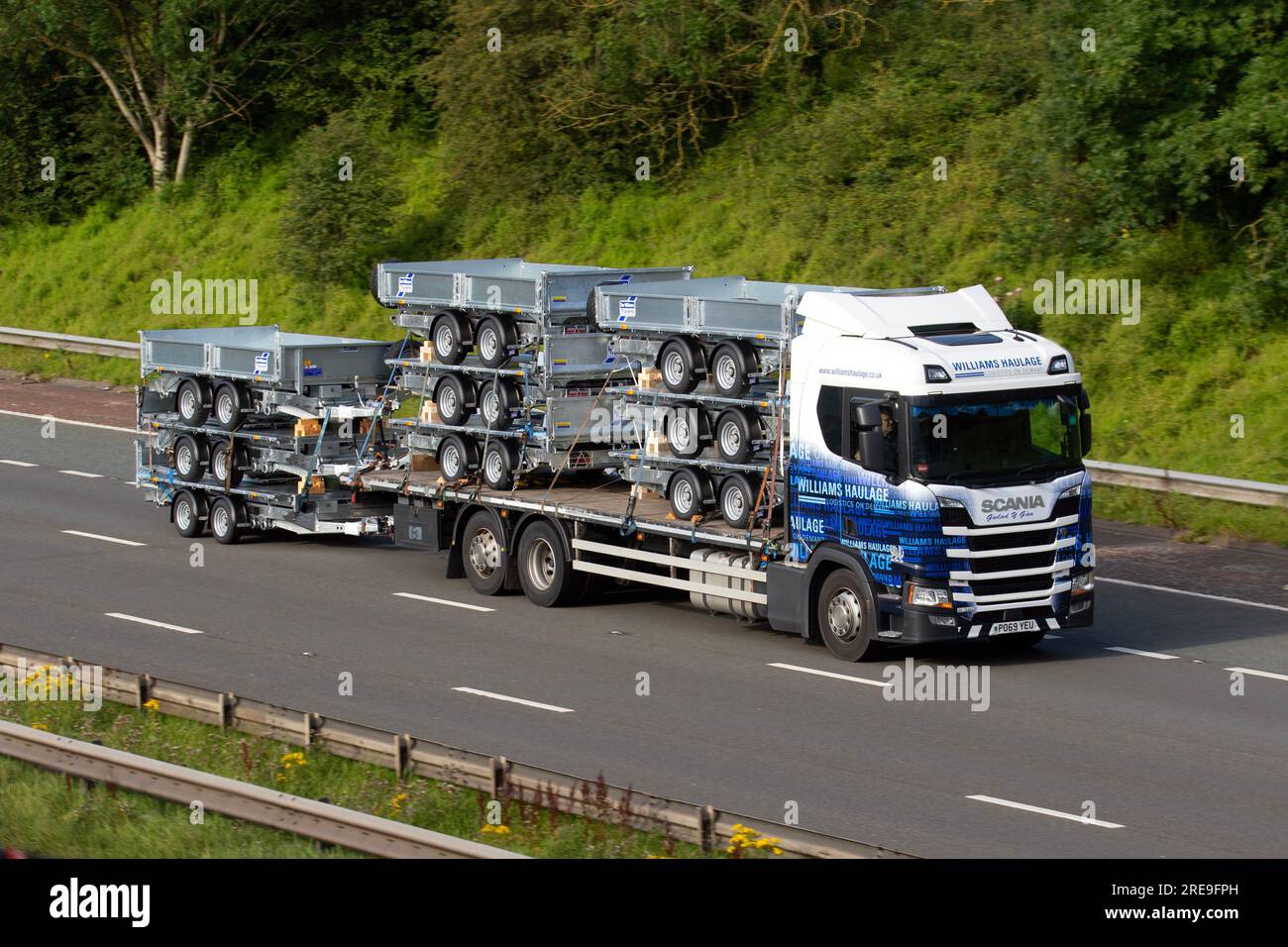 A delivery load of 9 new IFOR WILLIAMS LM85 TWIN AXLE FLATBED TRAILER/2700 GW trailers, loaded 2019 Williams Haulage Ltd Scania R440 Highline Diesel 9290 cc truck ; travelling on the M6 motorway in Greater Manchester, UK Stock Photo