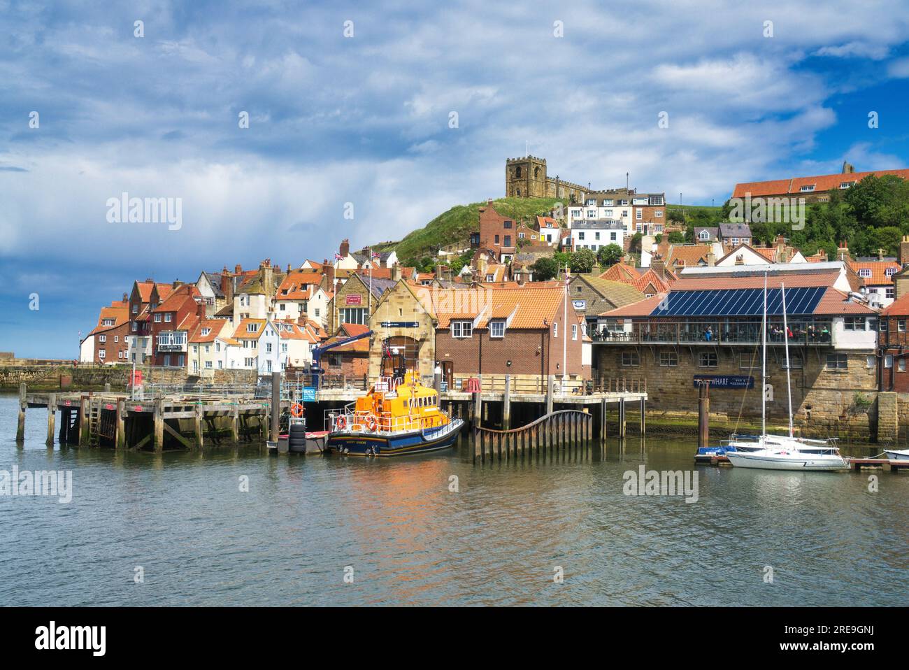 Looking  south from keyside, wharf, over the river Esk to   ruins of Whitby Abbey on Tate Hill.   Whitby, North Yorkshire coast , England, UK. Stock Photo