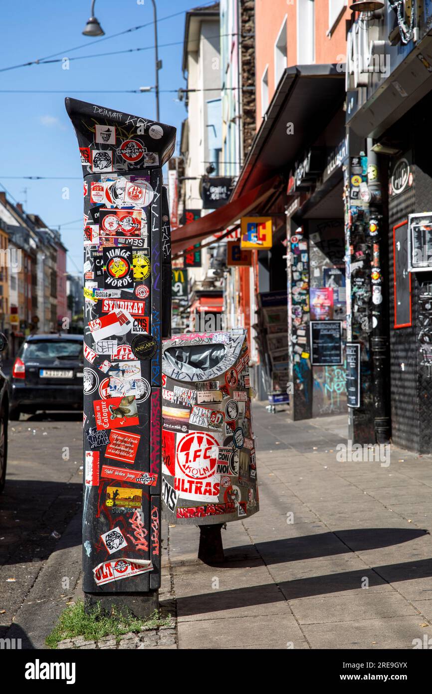 sticker on parking ticket machine, trash can and house entrance on Zuelpicher street, Cologne, Germany. Aufkleber auf Parkscheinautomat, Abfalleimer u Stock Photo