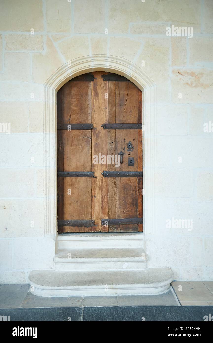 old wooden door with ironwork in a stone wall Stock Photo - Alamy